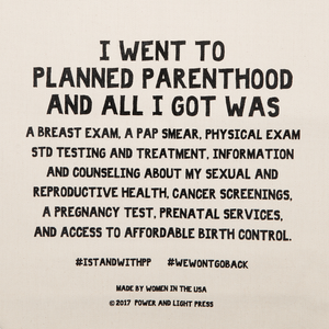 Zoomed in text on the planned parenthood canvas tote bag reading "I Went To Planned Parenthood And All I Got Was A Breast Exam, A Pap Smear, Physical Exam, STD Testing And Treatment, Information And Counseling About My Sexual And Reproductive Health, Cancer Screenings, A Pregnancy Test, Prenatal Services, And Access To Affordable Birth Control. #STANDWITHPLANNEDPARENTHOOD #WEWONTGOBACK.”